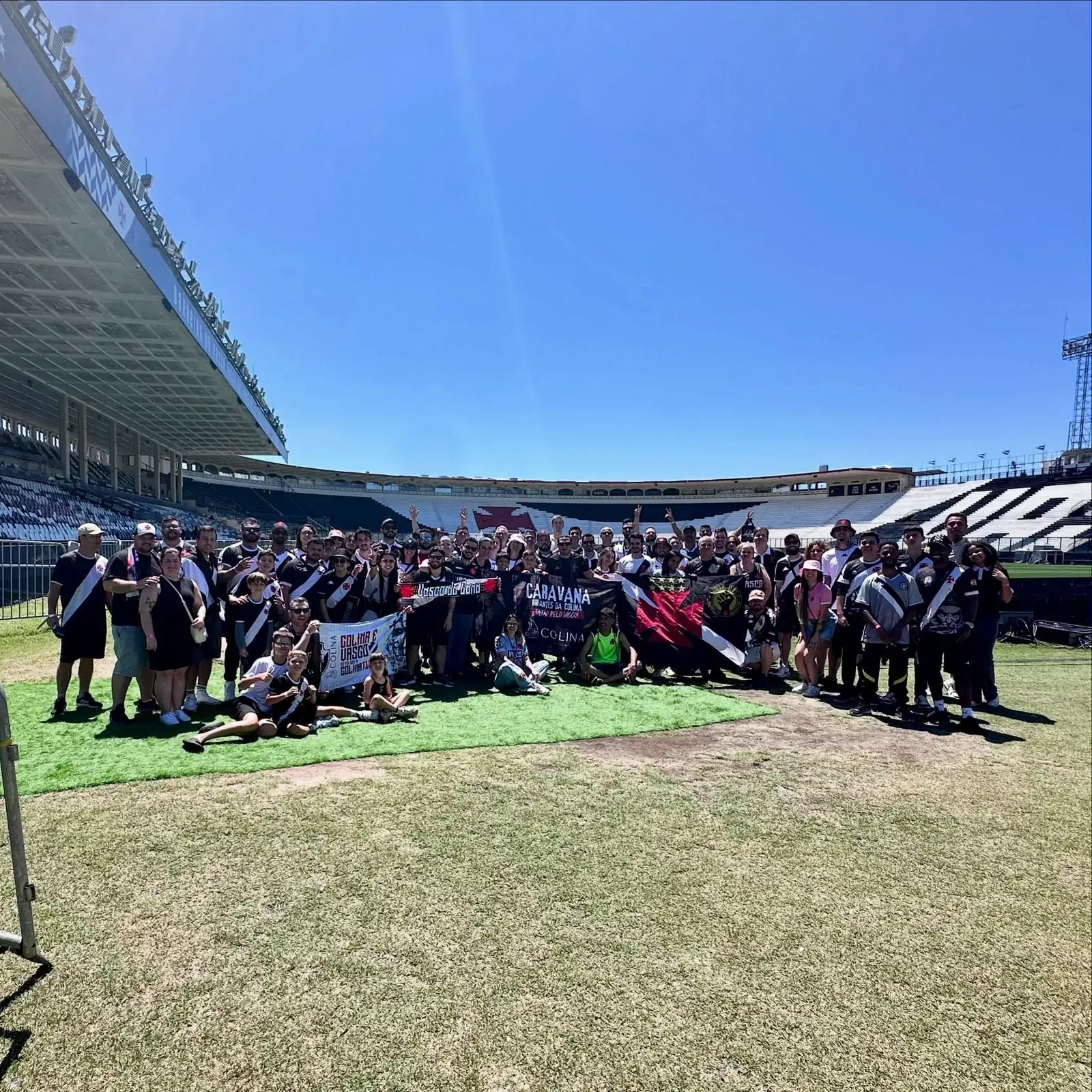 Passageiros da Colina Turismo reunidos no gramado do estádio